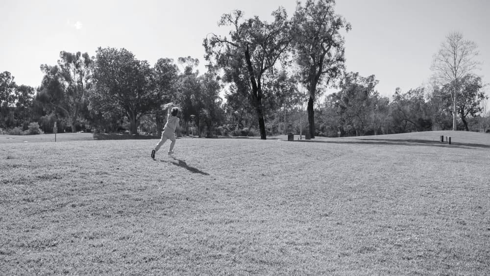A child running on a grass field in soft, overcast light