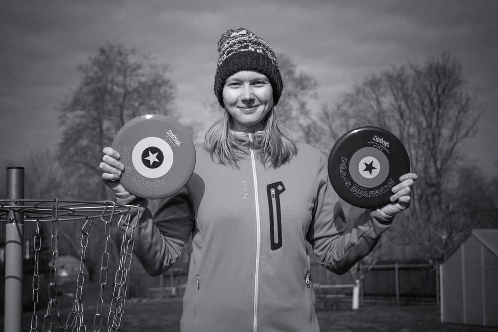 A disc golf putter held in a player's hand on an overcast day